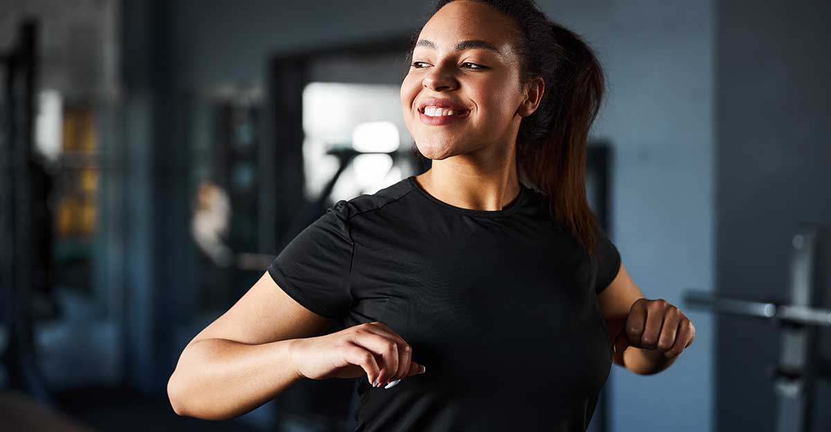 Young woman smiling while exercising in the gym