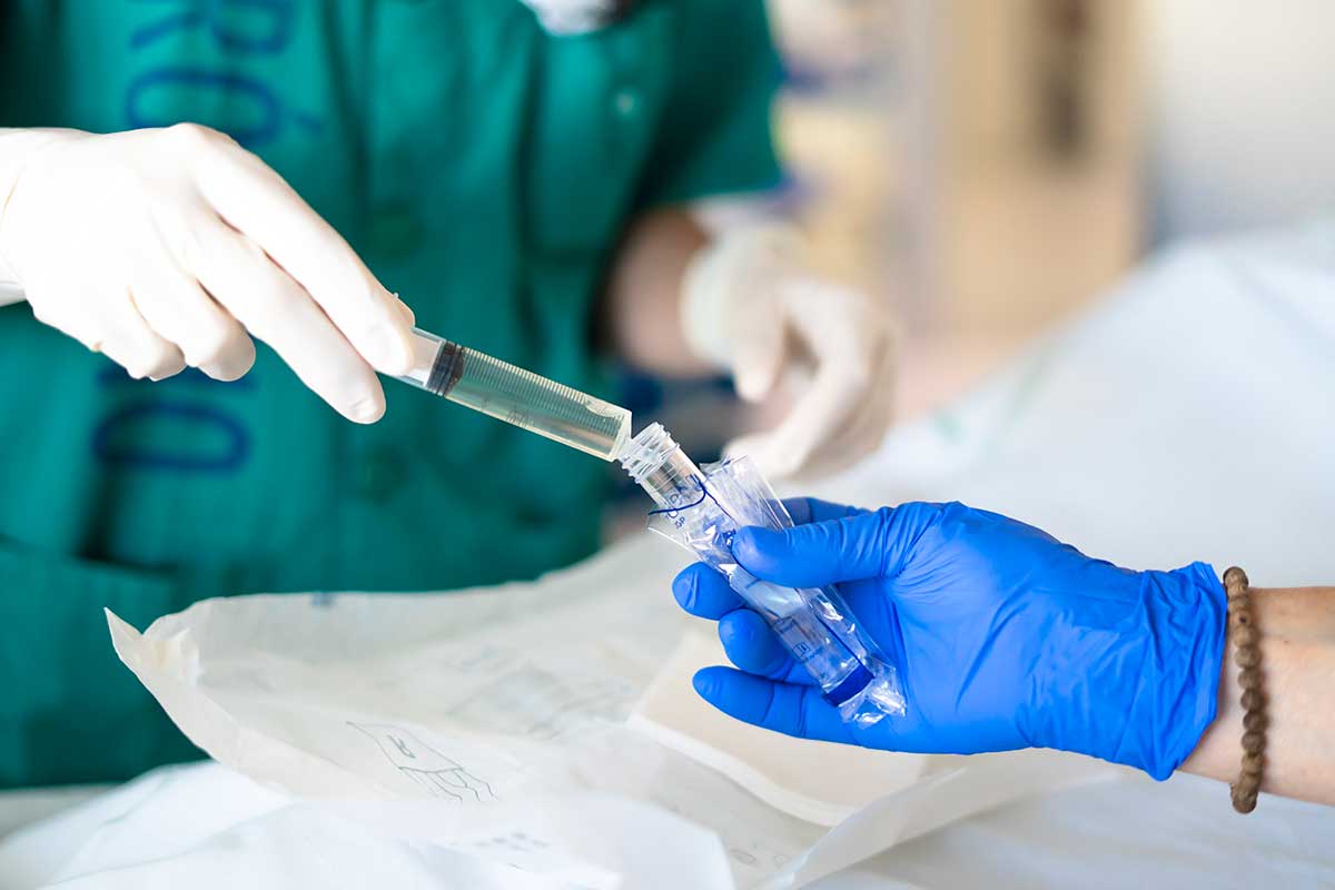surgeons injecting liquid into test tube